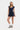 Woman wearing a navy polka dot dress on a white background