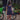 Woman in a navy blue dress standing next to a Lime electric bike on a brick path.