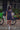 Woman in a navy blue dress standing next to a Lime electric bike on a brick path.